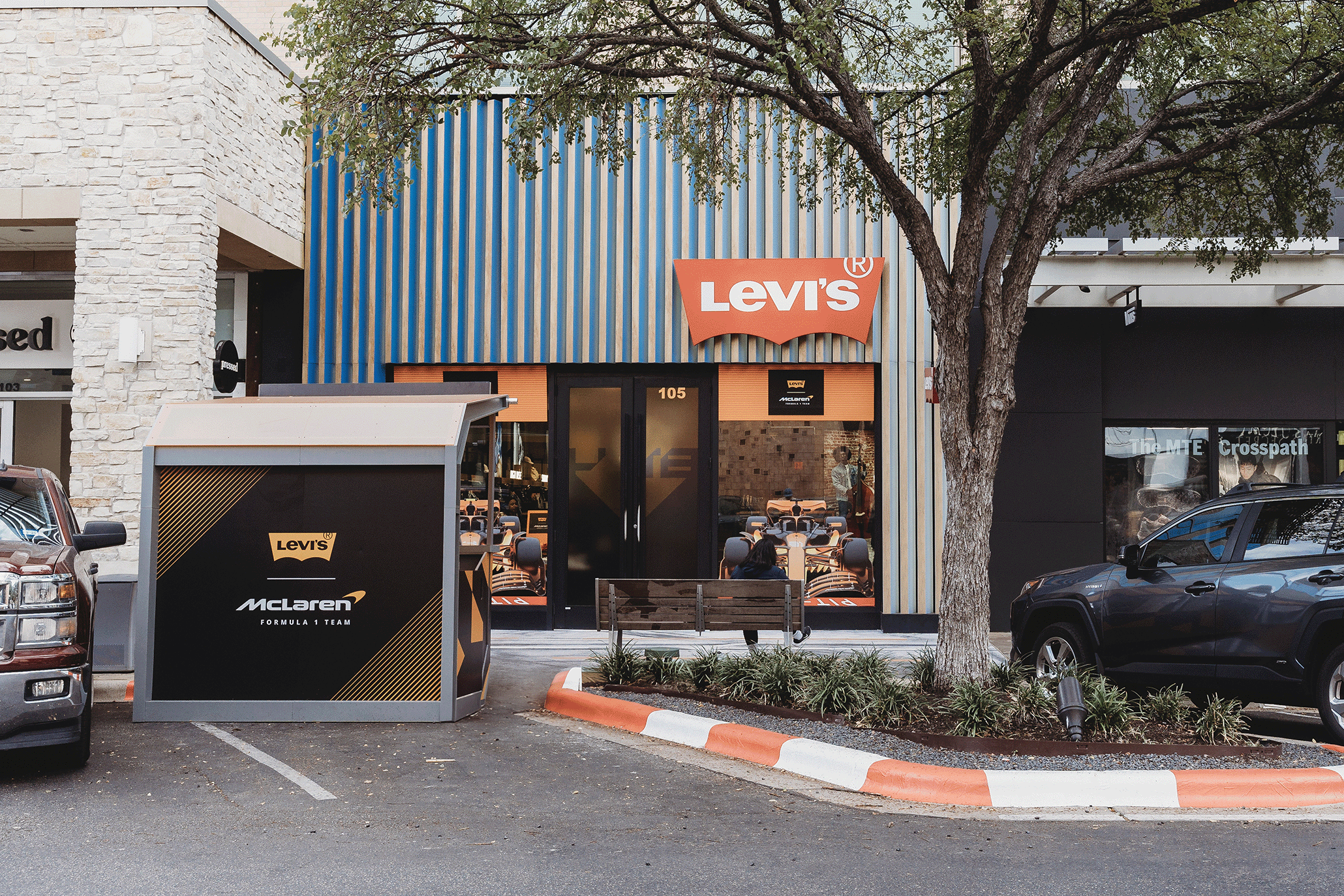 Exterior of a Levi's store in Austin, Texas decorated with McLaren Formula One branding, with a pit-lane style kiosk out front